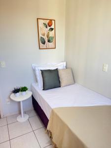 a small bedroom with a bed and a table at Melhor Experiência em Cuiabá in Cuiabá +7 photos