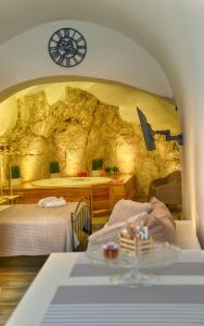 a bedroom with two beds and a rock wall at Suite Grotta della luna in Ostuni