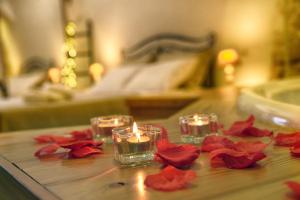 a table with two candles and red roses on it at Suite Grotta della luna - Romantic Luxury Jacuzzi in Ostuni