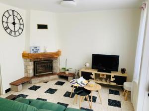 a living room with a green couch and a fireplace at Maison Familiale in Bonneval