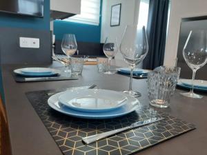 a table with plates and wine glasses on it at Downtown Apartment with Parking Amboise 2 in Vannes