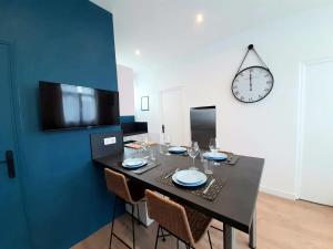 a dining room table with chairs and a clock on a wall at Downtown Apartment with Parking Amboise 2 in Vannes