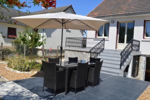 a table and chairs with an umbrella on a patio at Maison Familiale in Bonneval
