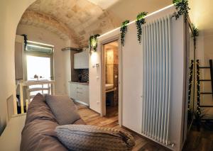 a living room with a couch and a kitchen at Suite Grotta della luna in Ostuni