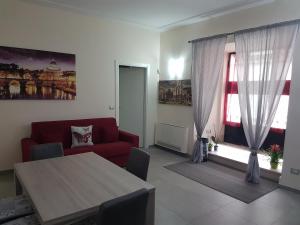 a living room with a red couch and a table at Bea&B in Rome