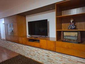 a television in a wooden entertainment center with a tv at Casa do Diniz in Travassos