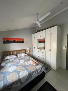 a bedroom with a bed and white cabinets at Cozy Nook Homestay in Nadi