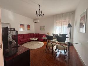 a living room with a red couch and a glass table at La casa di Biba in Bolsena
