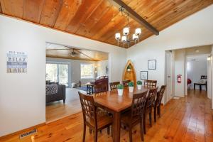 een eetkamer en een woonkamer met een houten tafel en stoelen bij Lovely Little Lake House in Brighton