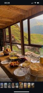 a table with food on top of it with windows at Guesthouse Kvavlo in Kvavlo