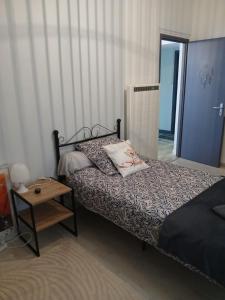 a bedroom with a bed and a table and a mirror at Gite les genêts in Le Vigeant