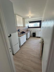 a kitchen with white cabinets and a wooden floor at Apartment 8 min Orly, 2 min RER, bus direct Orly in Ablon-sur-Seine