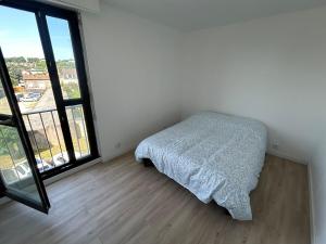 a bedroom with a bed and a large window at Apartment 8 min Orly, 2 min RER, bus direct Orly in Ablon-sur-Seine