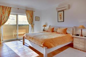 a bedroom with a bed and a large window at Casa Alha in Carvoeiro