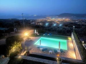a swimming pool with a view of a city at night at Villa Claudia in Apolpaina