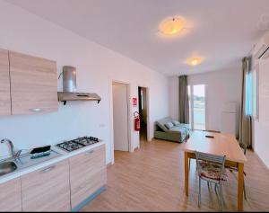 a kitchen and living room with a table and a stove at " la TONNARA CASA VACANZE " in Porto Cesareo