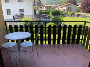 a balcony with two chairs and a table and a view at monolocale Emy in Valsassina in Introbio +2 photos