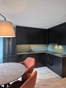 a kitchen with black cabinets and a table and chairs at Granli-Apartment in Stryn +17 photos
