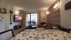 a living room with a table and a couch at Premium Oasis Beach Club Apartment in Lozenets