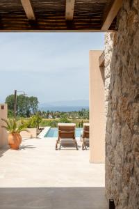a patio with two benches and a pool at Candelas Suites & Nature in Ierissos +22 photos