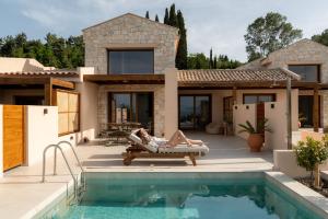 a woman laying on a chair next to a house at Candelas Suites & Nature in Ierissos