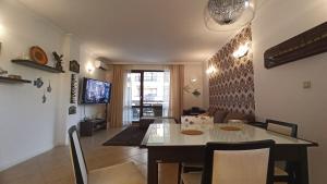 a dining room and living room with a table and chairs at Premium Oasis Beach Club Apartment in Lozenets