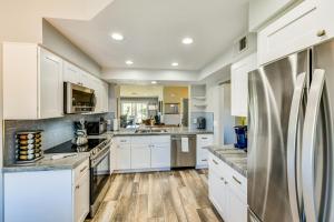 a kitchen with white cabinets and stainless steel appliances at Pool Access Newly Renovated Palm Desert Condo in Palm Desert