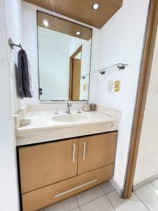 a bathroom with a sink and a mirror at Comoda Suite Cancun - BEACH CONDO - 6PX in Cancún