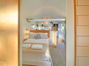 a small bedroom with a bed and a kitchen at The Little Barn in Hoxne