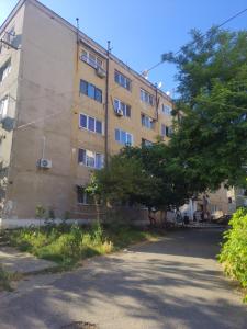 an apartment building with a tree in front of it at Home MARIA in Orşova