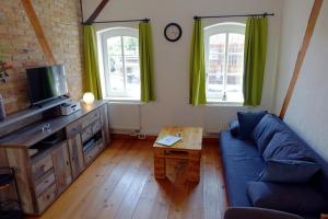 a living room with a blue couch and a table at Sonnenlandhof in Neuruppin