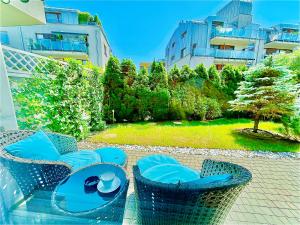 un tavolo e sedie su un patio con giardino di Bronowice Residence Blue - Homey Apartment with Garden and Parking a Cracovia