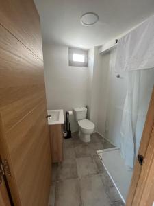 a bathroom with a toilet and a window and a door at Júcar Wine House in Alcalá del Júcar