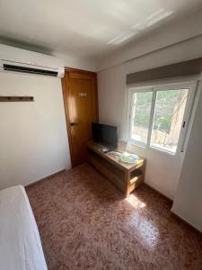 a bedroom with a bed and a desk and a window at Júcar Wine House in Alcalá del Júcar