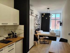 a kitchen and a bedroom with a bed in a room at Drzewna Apartamenty-Żeromskiego, Stare Miasto in Zielona Góra