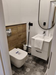 a bathroom with a toilet and a sink and a mirror at Drzewna Apartamenty-Żeromskiego, Stare Miasto in Zielona Góra +39 photos