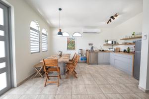 a kitchen and dining room with a table and chairs at Oceanfront 5BR Oasis w Decks & Direct Beach Access in Mayaguez