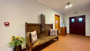 a wooden bench in a room with a door at Raízes da Vinha - Boutique Mountain Stay in Serra da Estrela, Seia in Carragozela