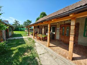 une terrasse couverte d'une maison avec une table et des chaises dans l'établissement La Tataia Zahei, à Drăguş