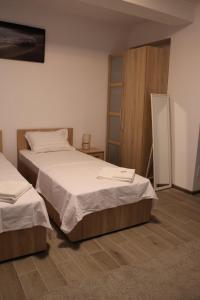 a bedroom with two beds and a cabinet at Parlament Residence in Bucharest +11 photos