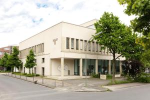 a white building on the side of a street at The Treasury Hotel in Neuss
