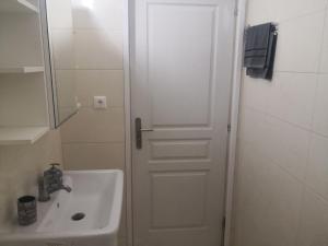 a bathroom with a sink and a white door at Anastasia in Leptokarya +13 photos