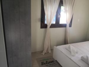 a bedroom with a white bed and a window at Anastasia in Leptokarya