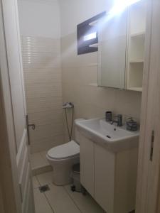 a white bathroom with a toilet and a sink at Anastasia in Leptokarya