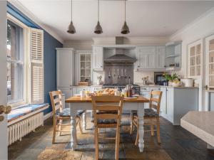 a kitchen with a table and chairs in a room at Westhill House in Warkworth