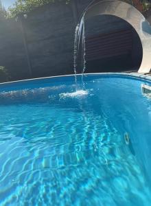 a water fountain in a swimming pool at НО home in Kholodnovidka +1 photo