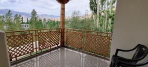 a balcony with a chair and a view of the mountains at Teyser Holiday Home in Leh +39 photos