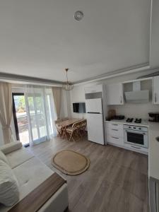 a kitchen and living room with a couch and a table at Datcha Cozyhomes Reşadiye in Datca