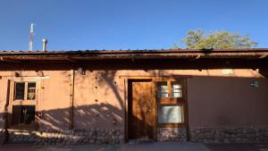圣佩德罗·德·阿塔卡马Elim Atacama的一座建筑,上面有门和两个窗户