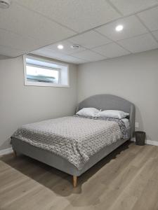 a bedroom with a bed in a room with a window at Jimmy in Winnipeg